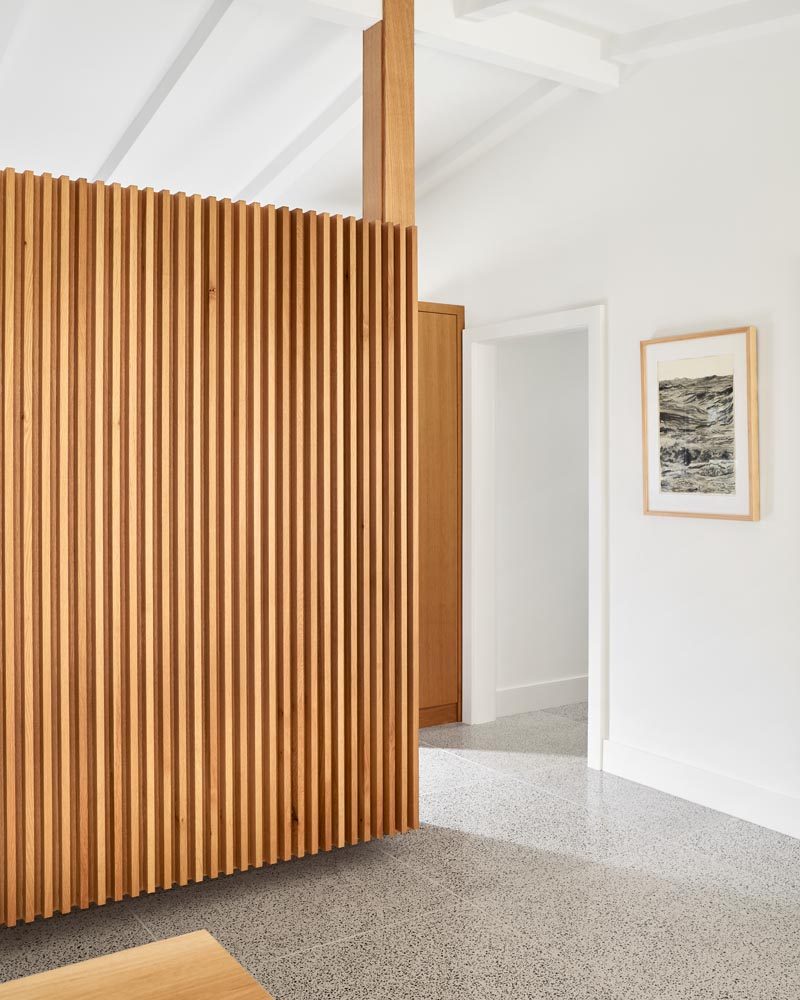 This renovated mid-century ranch house includes new custom details, like this wood paneling, while terrazzo floors have been installed throughout. #WoodPaneling #MidCenturyModern #TerrazzoFloors