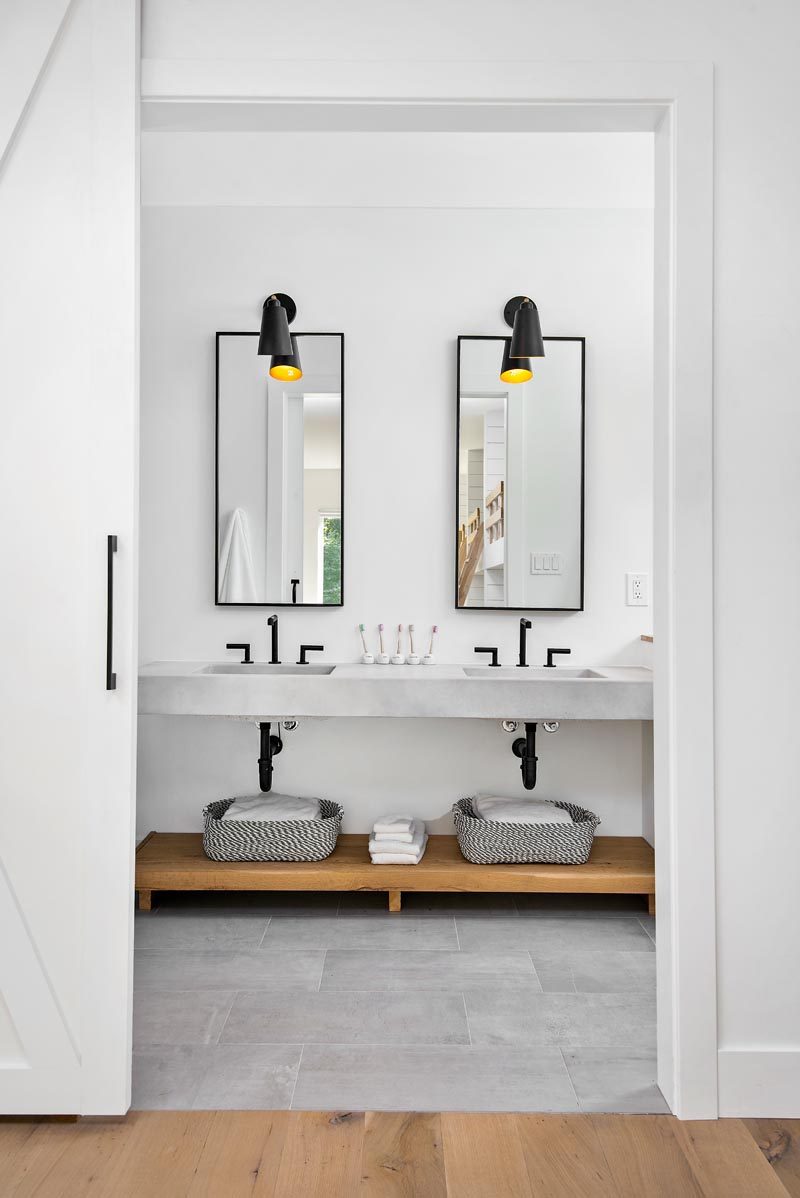 This modern bathroom features custom concrete counter tops by Chicago Concrete, concrete porcelain tile from Porcelanosa and Virginia Tile, wrought iron plumbing fixtures and accessories, and custom mirrors #ModernBathroom #ConcreteCounter #BathroomDesign