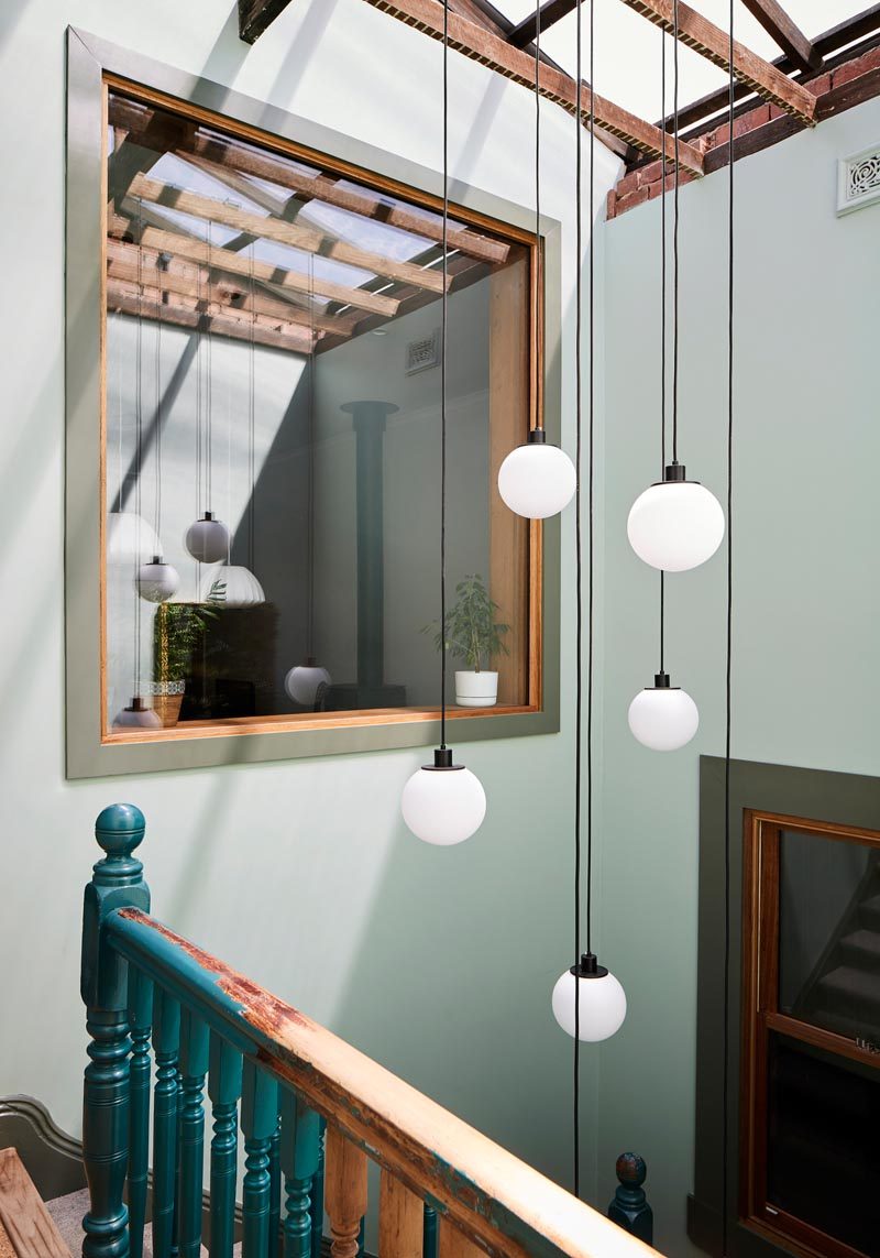 This two-storey apartment has an atrium that adds an abundance of natural light to the stairs, and provides a place for a pendant light installation. #Atrium #Skylights #InteriorDesign #Architecture