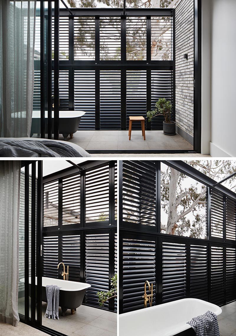 This modern bedroom enjoys a private balcony with a bath, so that the home owner could live out the dream of soaking in a steamy hot bath under the canopy of the stars and the gum tree. The black slat screen allows the breeze to filter through and also acts as a privacy screen. #ModernBedroom #ModernBalcony #OutdoorBathtub