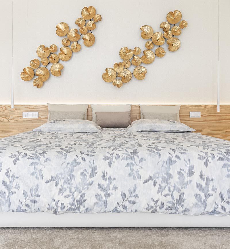 The wood accent adds a natural element to this modern bedroom and creates a headboard for the bed, while between the cabinets to the right of the bed, has hidden lighting, adding a soft glow to the room and highlighting the displayed objects on the shelf. #BedroomDesign #ModernBedroom #WoodAccent, #Lighting