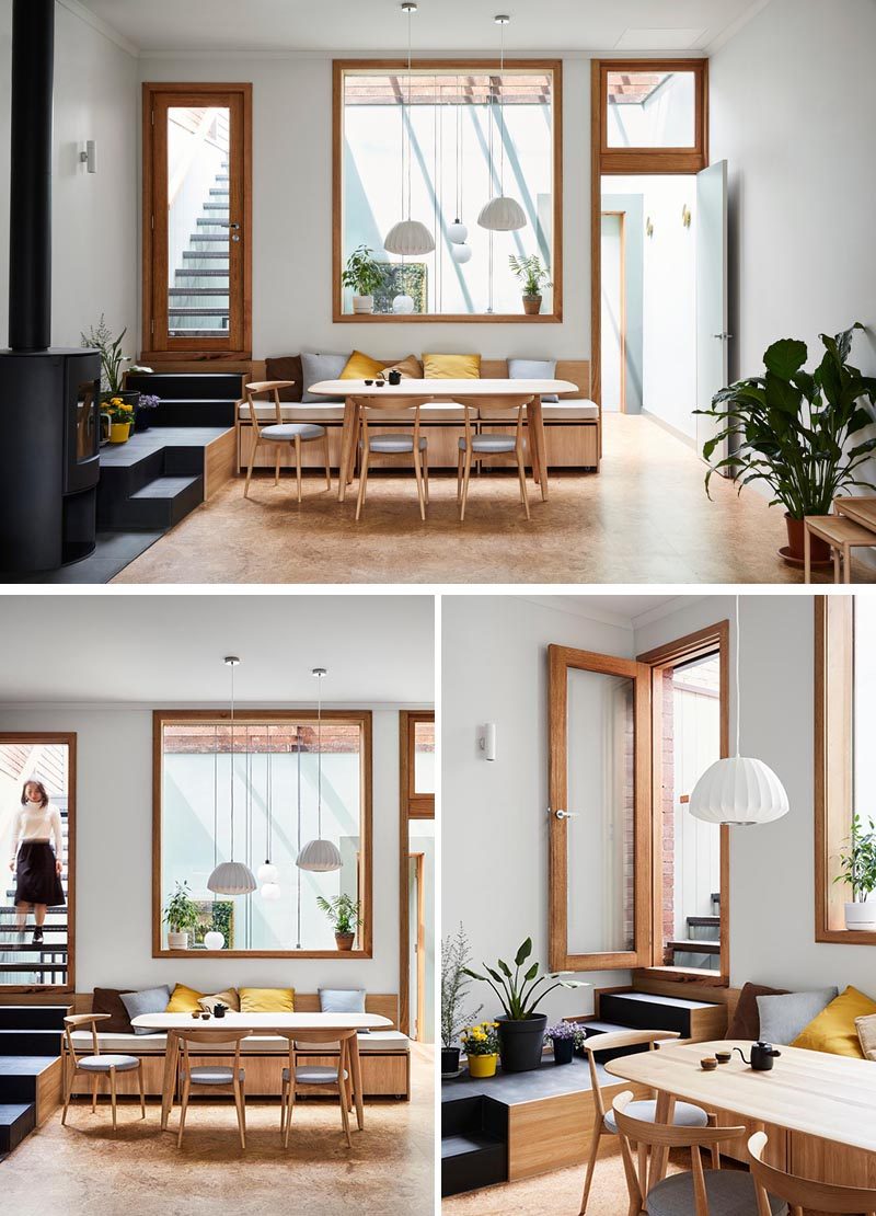 This casual and modern dining area has built-in bench seating and a large window. Stairs lead from the dining area up to a rooftop deck. #DiningRoom #BuiltInBench #Windows #Stairs