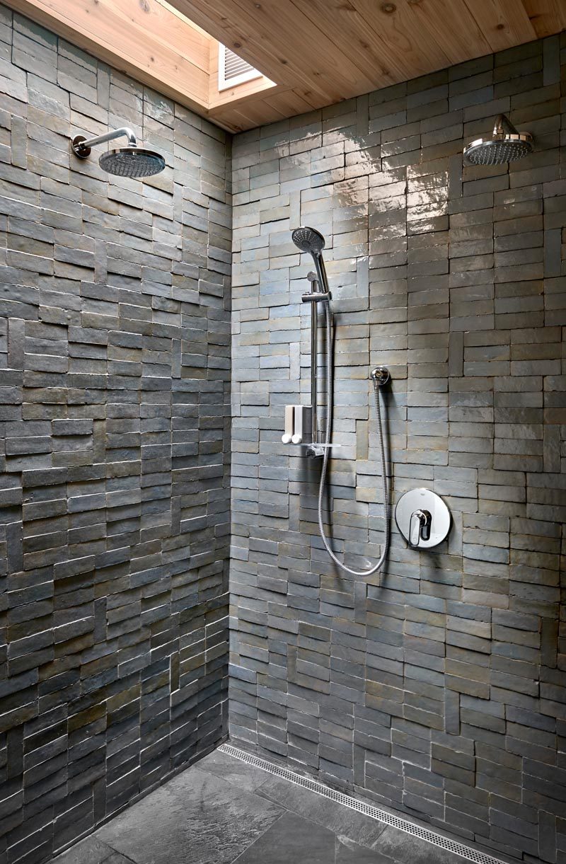 This modern bathroom has a shower with a skylight that highlights the texture and coloring of the handmade tiles that clad its walls. #Shower #ShowerDeisgn #BathroomDesign