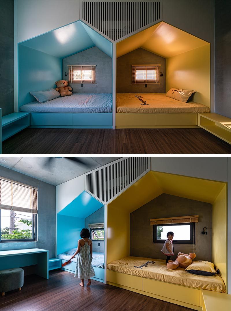 This modern bedroom, which features wood floors, has two mini 'houses' that define the separate sleeping areas for the children. The houses, each with their own window, create a little nook for each child, giving them their own space when needed, while a combined shelf and desk is color matched to the bed. #KidsBedroom #BedroomDesign #SharedKidsBedroom #ChildrensBedroom #ModernKidsBedroom