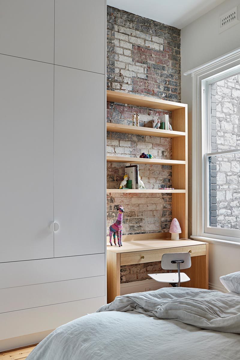 In this modern kid's bedroom, the original brick wall becomes the backdrop for a homework station. #ModernKidsBedroom #HomeworkStation