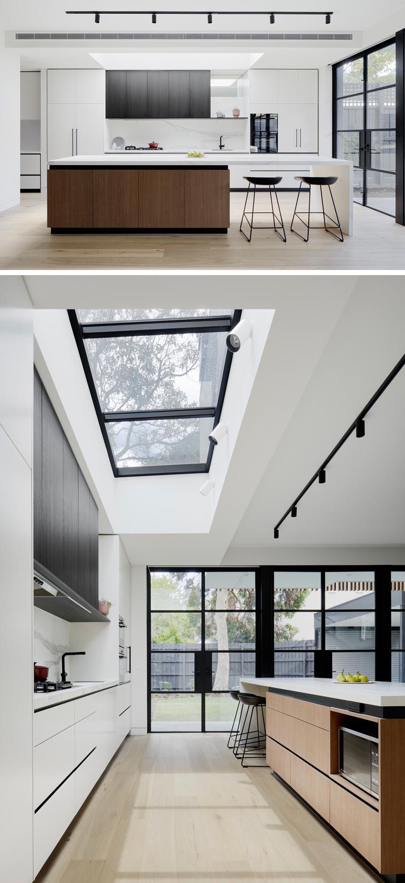 This modern kitchen was designed with an oversized island with room for seating, while subtle textures and fine black shadow lines complement the door frames. A large skylight central to the kitchen adds even more natural light to the interior. #ModernKitchen #WhiteKitchen #Skylight #KitchenIsland