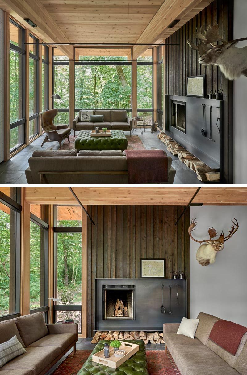 This modern living room showcases a charred cedar accent wall with a hand worked blackened steep fireplace surround. #Fireplace #LivingRoom #Windows #WoodAccentWall