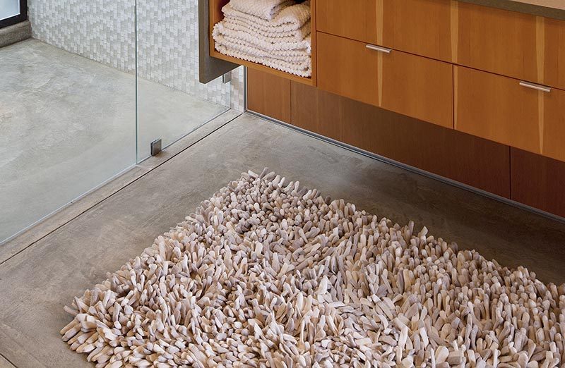 The floors throughout this modern bathroom are concrete with a soy based stain and sealer, while a shag rug adds a soft touch underfoot. #ModernBathroom #ConcreteFloors