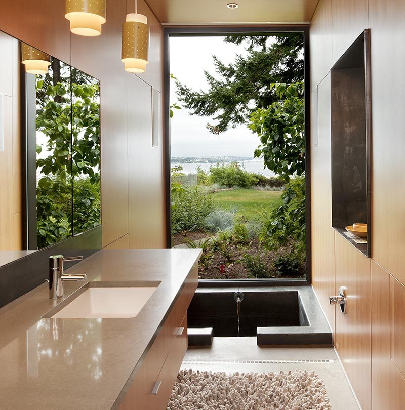 Enjoying the view of this modern bathroom is the 'ofuro' or Japanese style soaking tub. The custom one-of-a-kind bathtub measures in at 3.5' long x 4.5' wide x 4' deep and is made from cast in place concrete. #SunkenBathtub #JapaneseSoakingTub #ModernBathroom #BathroomDesign