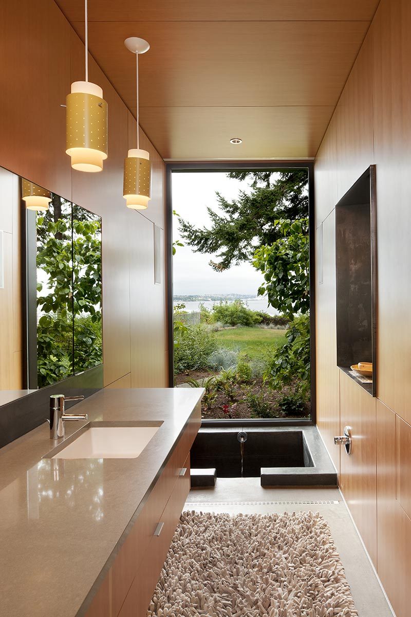 Enjoying the view of this modern bathroom is the 'ofuro' or Japanese style soaking tub. The custom one-of-a-kind bathtub measures in at 3.5' long x 4.5' wide x 4' deep and is made from cast in place concrete. #SunkenBathtub #JapaneseSoakingTub #ModernBathroom #BathroomDesign