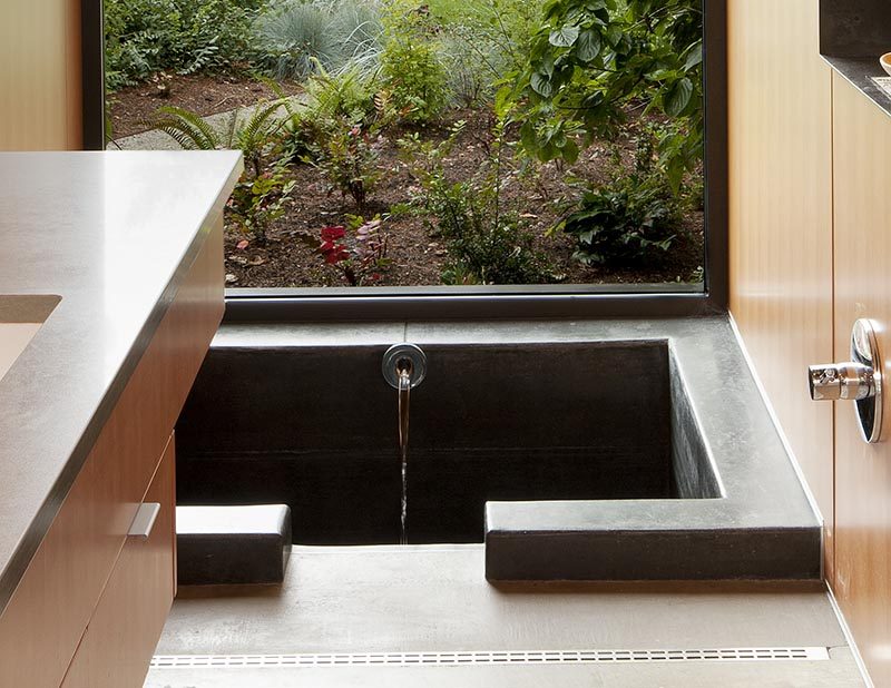 Enjoying the view of this modern bathroom is the 'ofuro' or Japanese style soaking tub. The custom one-of-a-kind bathtub measures in at 3.5' long x 4.5' wide x 4' deep and is made from cast in place concrete. #SunkenBathtub #JapaneseSoakingTub #ModernBathroom #BathroomDesign