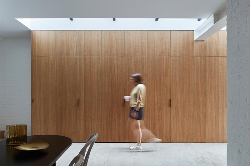 This modern house extension has skylights that run between the dining room and the kitchen, that also highlight the wood cabinets. #Skylights #WoodCabinets