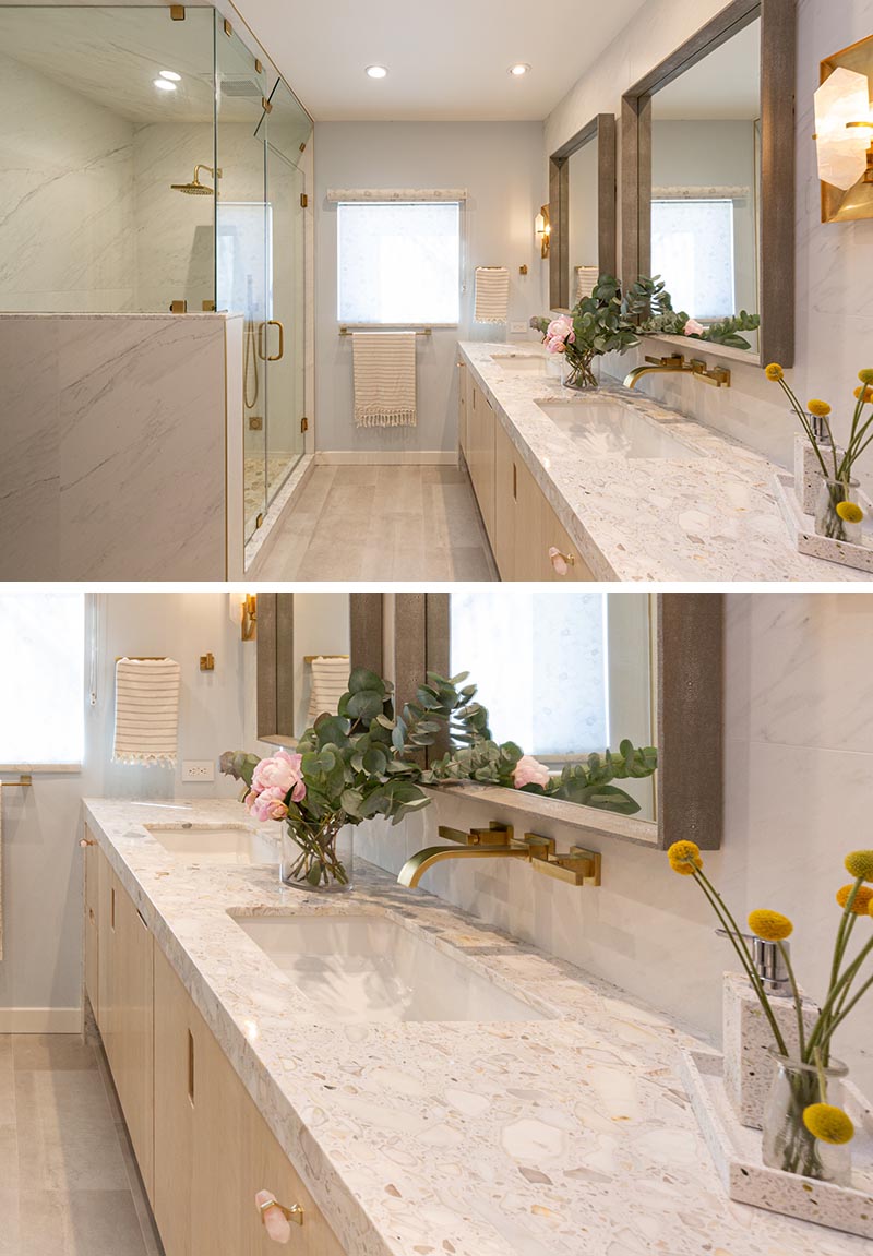 This double-vanity, which travels to the end of the bathroom, has a stone countertop, with undermount sinks, and two square wood-framed mirrors. #ModernBathroom #BathroomVanity