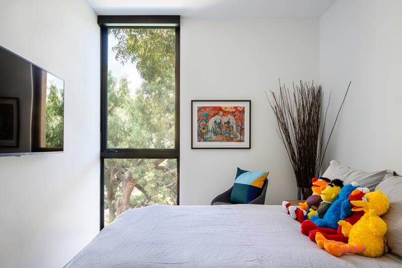 In this modern bedoom, colorful accents brighten up the mostly white interior. #ModernBedroom #BedroomDesign