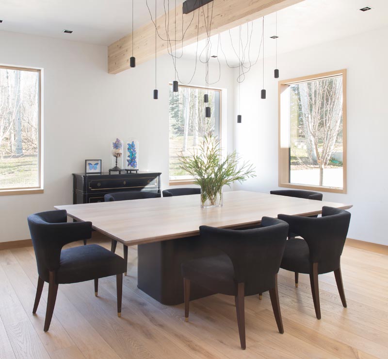 This modern dining room has contrasting elements, like a black table base and wood table top, black chairs furnishings and white walls. #DiningRoom #ModernDiningRoom