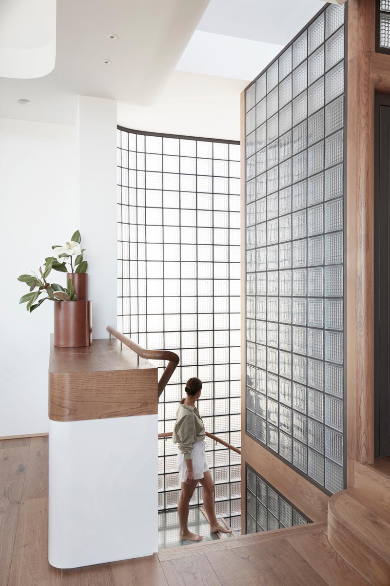 This modern house features a stairwell surrounded by glass blocks with black grout, and steel, wood, and glass treads. #ModernGlassBlock #GlassBlock #Stairs #Stairwell