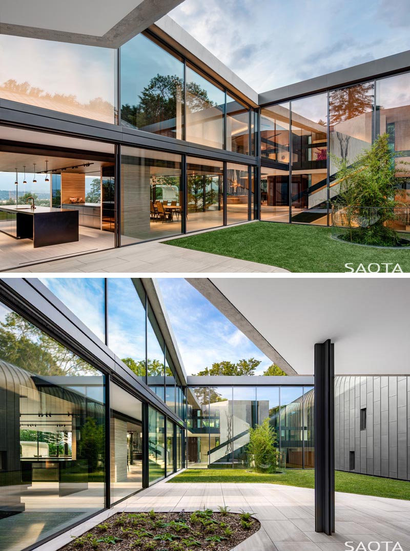 Sliding glass doors open up this modern kitchen to an internal open-air courtyard. #Courtyard #GlassWalls