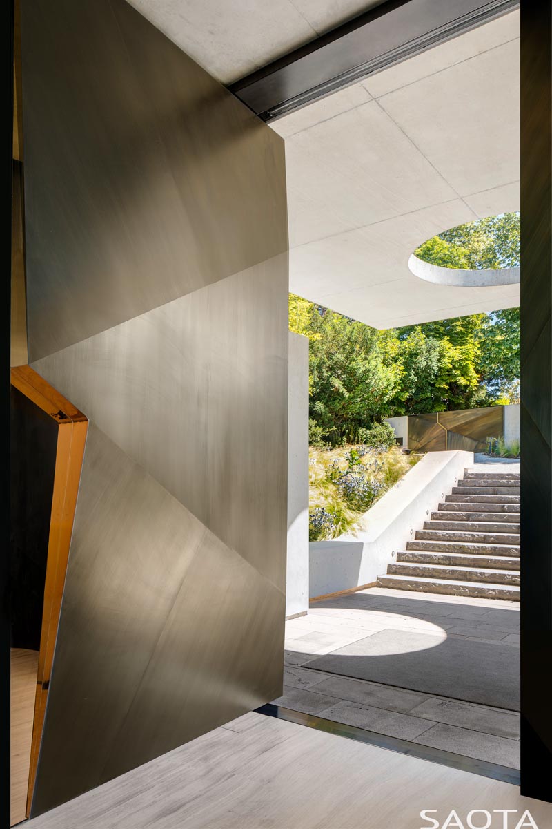 This modern and large pivoting front door clad in copper, has angles that create a sense of interest the moment you step through the doorway. #CopperFrontDoor #FrontDoor #DoorIdeas