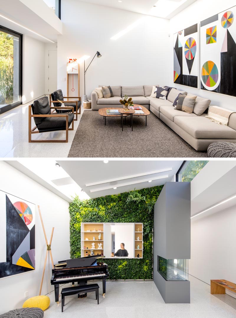 This modern living room features double height sloping ceiling with clerestory windows, skylights, and a living wall with an opening through to a pantry. #LivingRoom #Windows #GreenWall #LivingWall