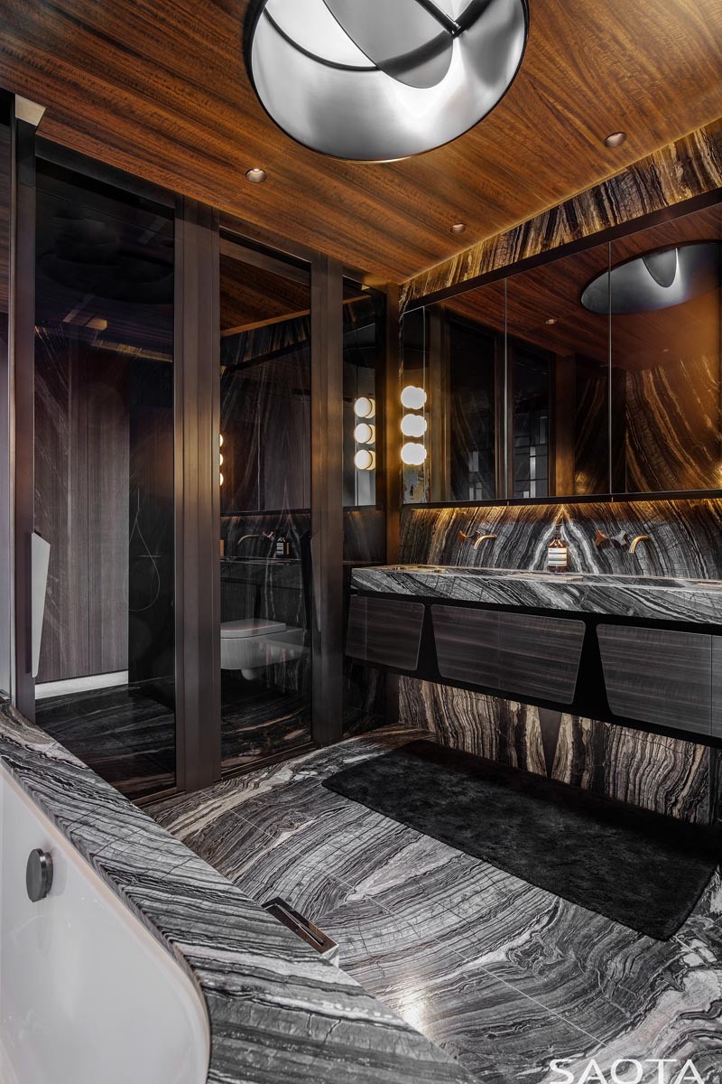 This modern bathroom features black and white stone and a rich wood ceiling. #ModernBathroom #Stone #WoodCeiling