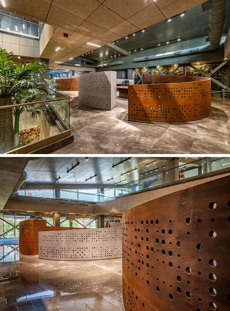 The curved perforated panels of this modern workplace feature a grid of differently sized circles that let the light travel through. #WorkplaceDesign #OfficeDesign