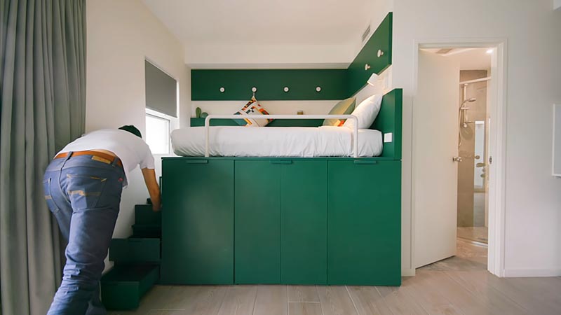 At the end of the under-bed storage, there's a small set of stairs that lead up to the platform bed. When there's a shortage of space in an apartment, stairs can also double as storage places, like these, that act as drawers. #PlatformBed #SmallLiving #BedWithStorage #StairsWithStorage