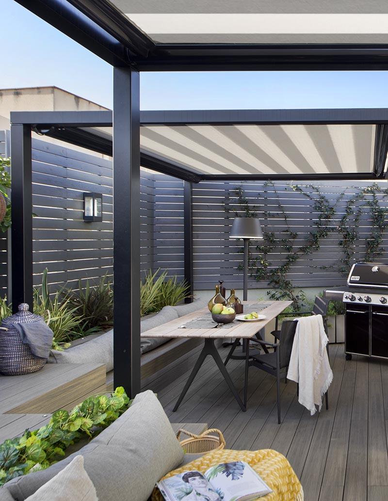 This modern outdoor terrace has a dining area with bench seating that matches the nearby lounge, while the grey wood slat fence adds to the modern feeling of the space. #OutdoorTerrace #OutdoorDining #OutdoorEntertaining