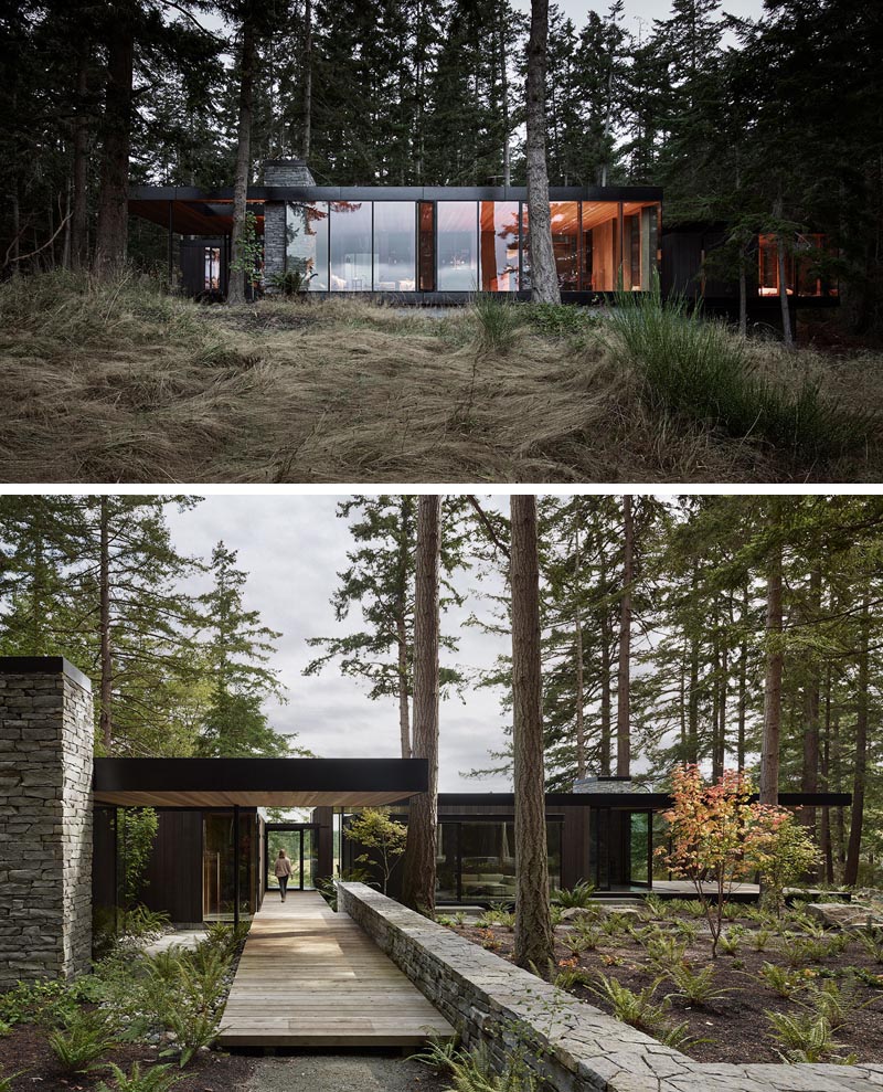 This modern house is situated on the edge of a forested hillside, overlooking chicken sheds, a weathered red barn, cattle fields, and a fishing pond. #ModernHouse #DarkWoodSiding #Architecture