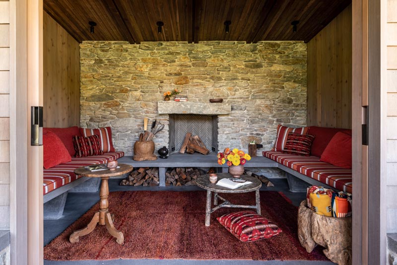 This inglenook, also known as a chimney room, has a cozy feeling with a fireplace surrounded by a stone wall and even further built-in seating.