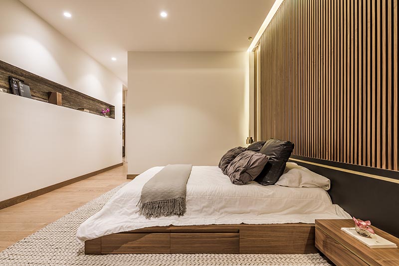 This built-in shelving niche adds interest to the otherwise plain white wall in this modern bedroom, and provides a place to store books and display decorative items. #ShelvingNiche #BuiltInShelf #ShelfDesign #ModernBedroom #BedroomDesign