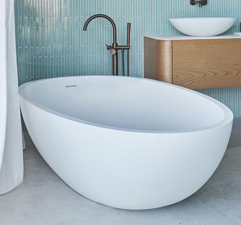 A freestanding white rounded bathtub complements the vanity sinks, while the bronze faucet adds a metallic touch. #ModernBathroom #WhiteBathtub #BathroomDesign