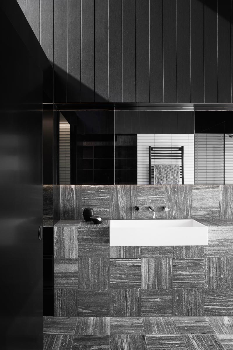 This modern black and white bathroom has a grey tile laid in opposite directions adding visual interest to the space. #BathroomDesign #ModernBathroom