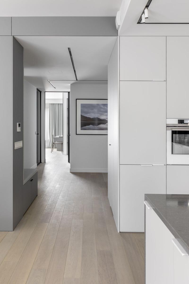 A small hallway connects the social areas of this modern apartment with the bedroom. The hallway also acts as a foyer as it passes by the front door. #ModernApartment #ApartmentDesign #Hallway