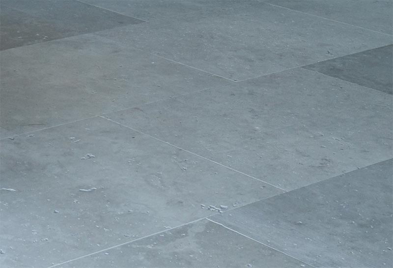 The floor of this modern bathroom is covered in large format grey tiles that have thin grout lines. #GreyTiles #BathroomFloor