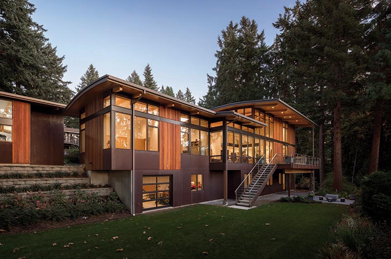 A modern house with plenty of windows, weathering steel, and ipe wood siding.