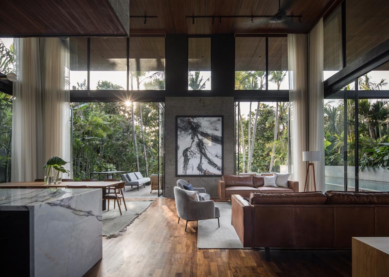 The social areas of this modern house are all open plan, with double height ceilings and large glass walls that open to let the breeze flow through. #ModernInteriorDesign #DoubleHeightCeiling #GlassWalls