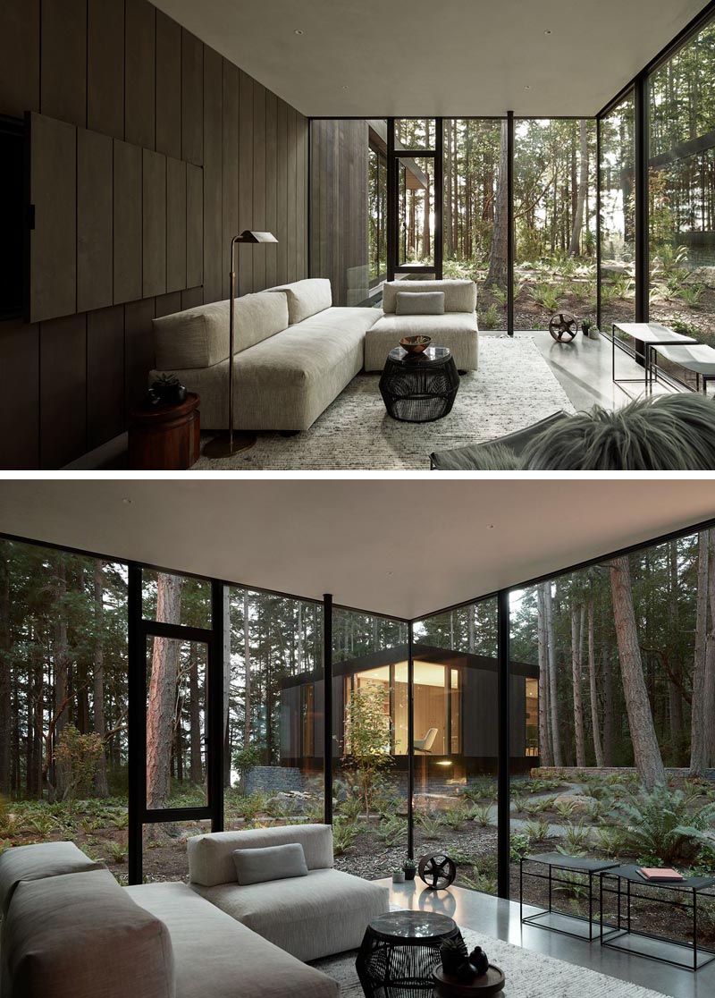 This living room features a dark wood wall and views of another part of the home that stands separately from the main house. #LivingRoom #DarkWoodWall