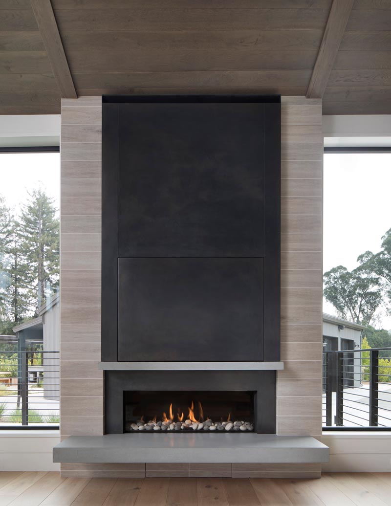 A built-in linear fireplace with a cantilevered hearth and steel surround.