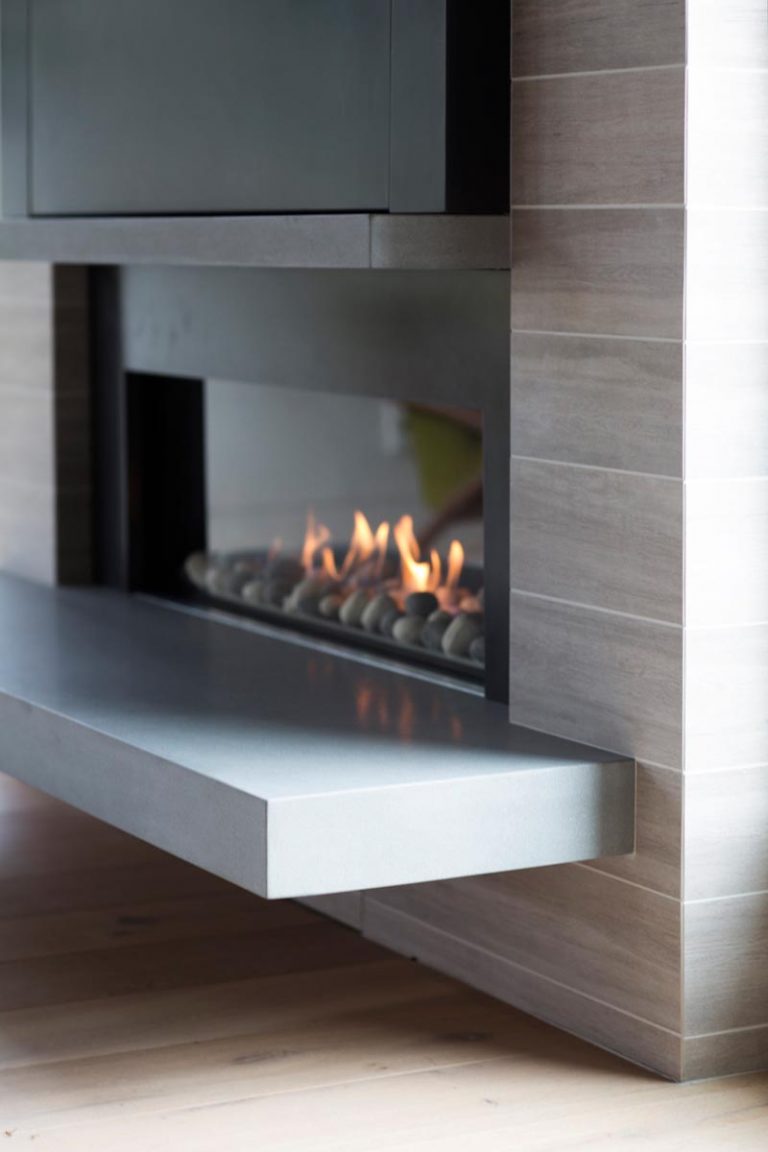 A Linear Fireplace With A Steel Surround And Cantilevered Hearth Is The