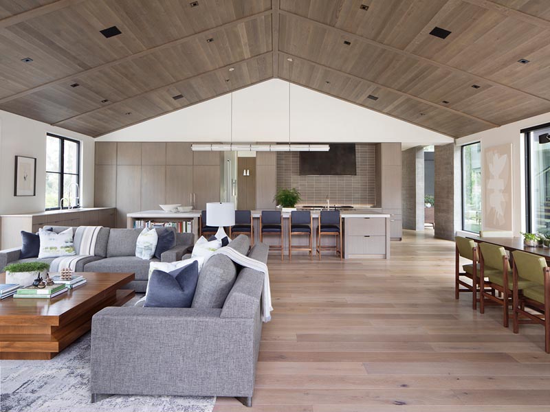 To complement the neutral color palette found throughout the interior of this modern farmhouse in California, the ceiling of the great room was lined with wood, adding warmth and a natural element. #WoodCeiling #ModernFarmhouse #GreatRoom