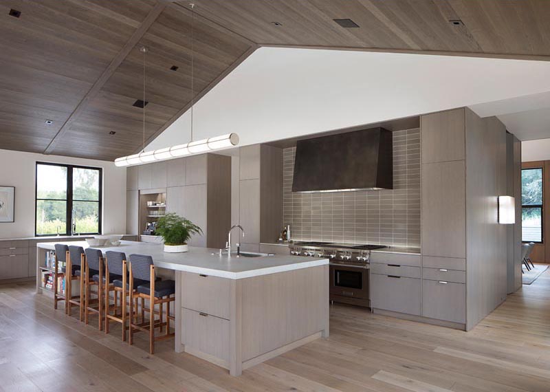 To complement the neutral color palette found throughout the interior of this modern farmhouse in California, the ceiling of the great room was lined with wood, adding warmth and a natural element. #WoodCeiling #ModernFarmhouse #GreatRoom