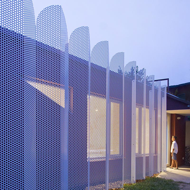 Architect and designer Francesca Perani has created a micro-apartment in Bergamo, Italy, that features a perforated metal screened facade. #MetalScreen #PrivacyScreen #Architecture #BuildingDesign