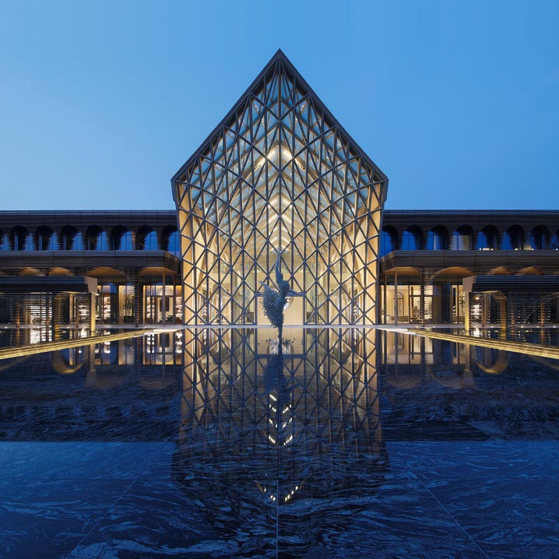 A modern sales center with glass walls and a reflection pool. #Architecture