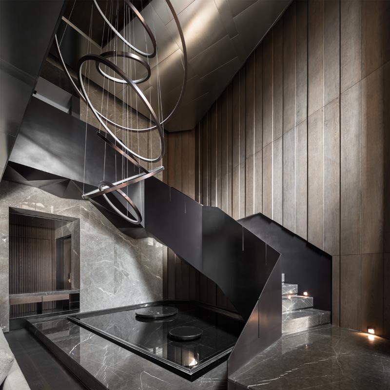 Black steel stairs and a sculptural light add a dramatic flair to this modern interior. #BlackStairs #SteelStairs #Lighting