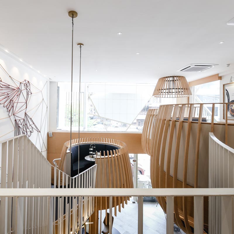A modern dessert restaurant with custom-designed wood pods. #RestaurantInterior #InteriorDesign
