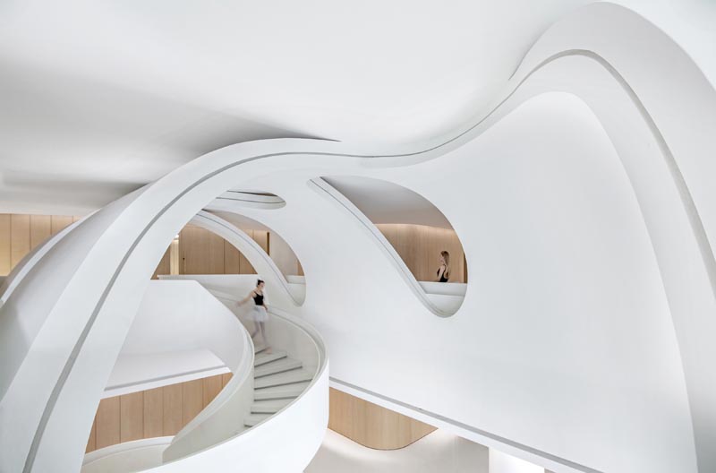 Curved details adds interest to this white and wood educational building. #InteriorDesign #Architecture