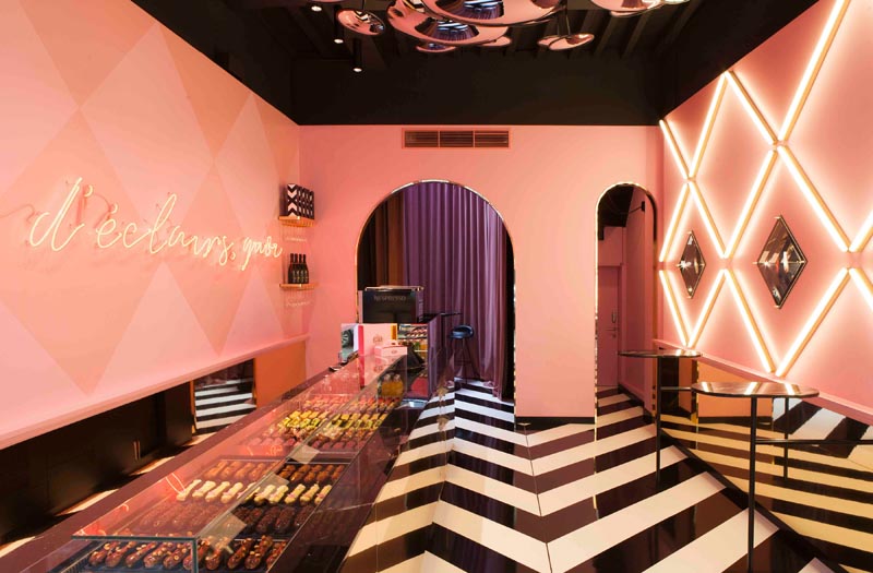 A modern bakery with pink walls and black and white flooring. #Bakery #ModernBakery