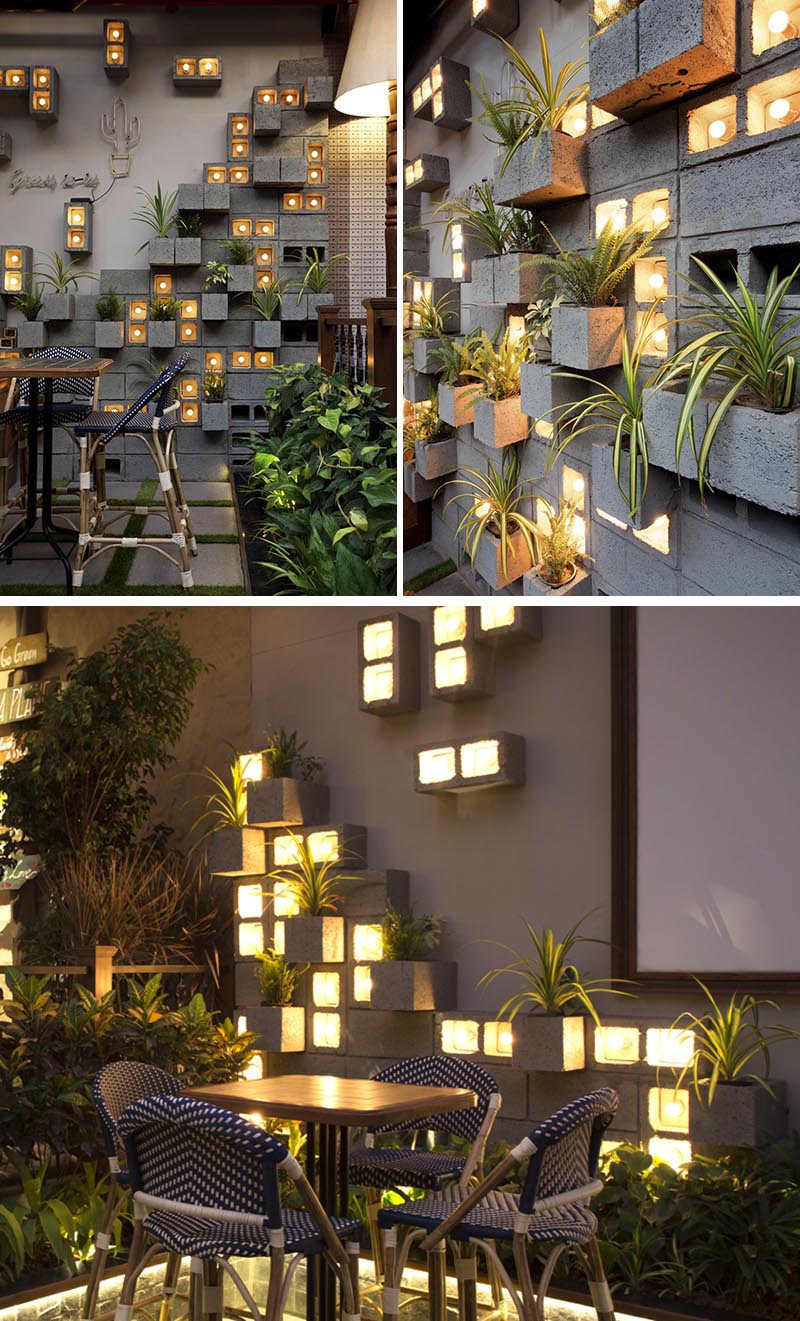 Concrete blocks were used to create this modern eye-catching accent wall, with some of them turned to become planters, slightly protruding to make room for the plants. Other blocks have been turned on their side to make room for individual light bulbs adding a soft glow of the light to the scene. #ConcreteBlockPlantWall #ConcreteBlockPlanter #CinderBlockPlanter 