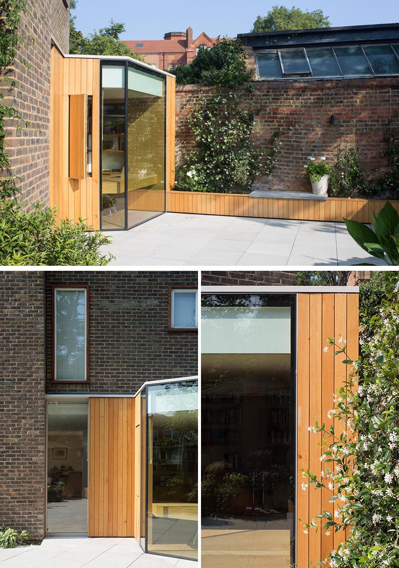 This modern home office design is a spacious and light filled extension that features a folding facade of glass and oak, while inside there's custom designed bookshelves and two desks. #HomeOffice #HomeOfficeDesign #Architecture