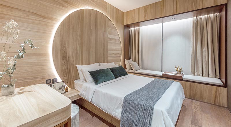 Bedroom Idea - Using natural materials to create a sense of warmth and calm, the design of this circular headboard observes the Chinese concept of “Earth’s a square; heaven a circle”. It also has hidden lighting that creates a soft glow and outlines the design element. #BedroomIdeas #HeadboardIdeas #CircleHeadboard #CircularHeadboard #Lighting